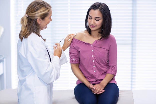 Doctor giving an injection to the patient