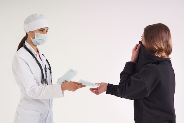 Doctor giving a patient protective face mask to protect from virus infection, coronavirus concept