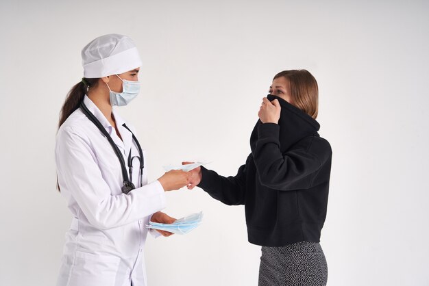 Doctor giving a patient protective face mask to protect from virus infection, coronavirus concept