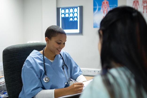 Doctor giving prescription to pregnant woman at desk