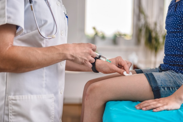 Doctor giving a young girl a vaccine shot