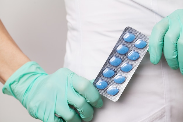 Doctor in gloves holds pills for men's sexual health