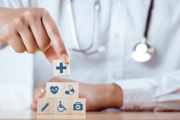 Doctor hand arranging wood block with healthcare medical icon on white background Health care