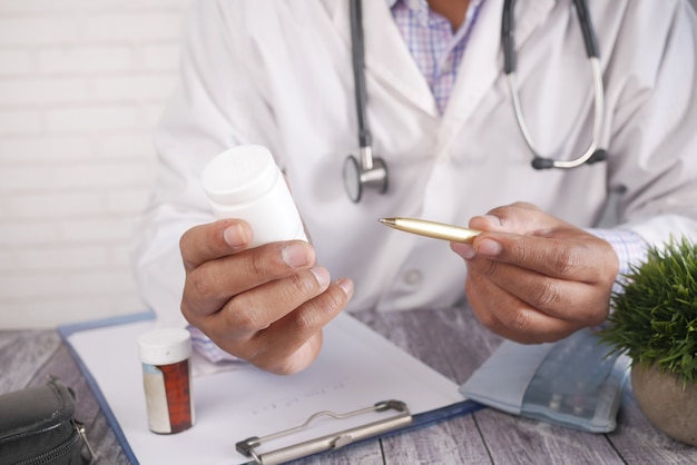 Doctor hand holding pill container with copy space