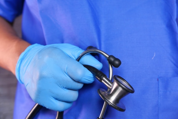 doctor hand in protective gloves holding stethoscope