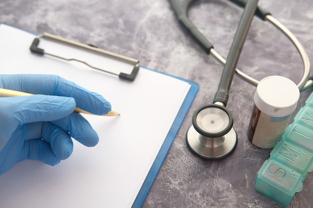 doctor hand in protective gloves writing prescription,