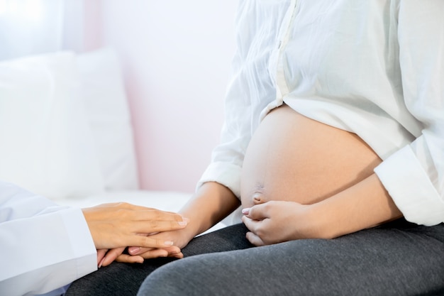 doctor hand touch with careful with pregnancy women in the hospital.