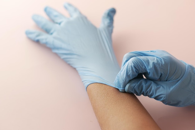 Doctor hand with glove on wooden background