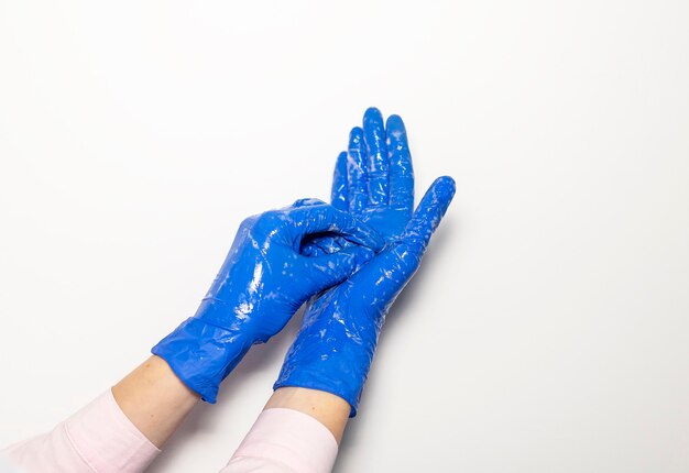 Foto mani del medico in guanti con stetoscopio, concetto di esame medico su sfondo bianco.