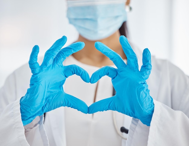 Doctor hands and heart sign for covid healthcare love or trust for health and safety at the hospital Hand of female nurse showing hearty emoji icon or gesture in medical protection at the clinic