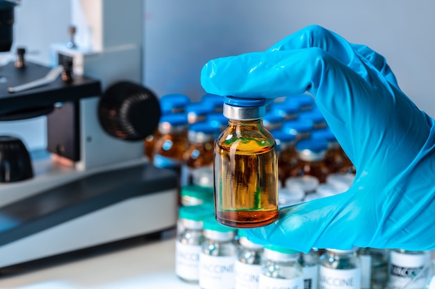 Doctor hands holding glass vial with medication