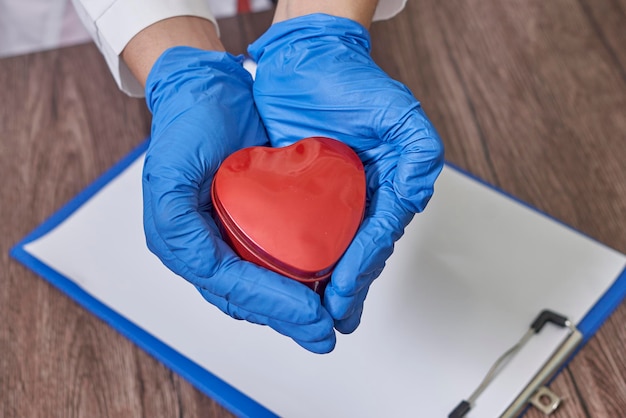 Doctor hands holding heart donation and implantation medic saving life