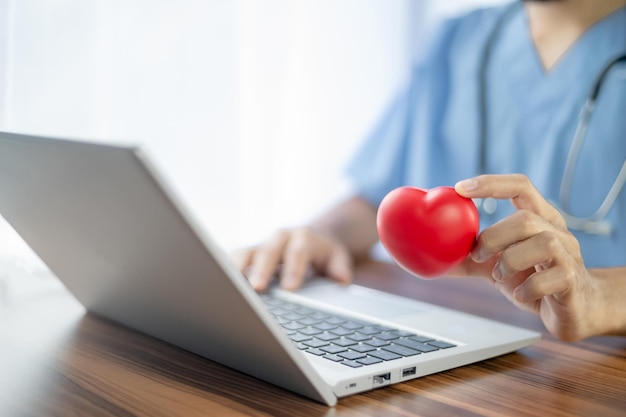 Doctor hands holding red heart health care love organ donation\
mindfulness wellbeing family insurance and csr concept world heart\
day world health day national organ donor day