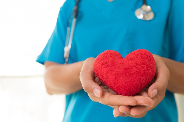 의사가 손을 잡고 붉은 심장. 건강 관리 개념입니다.