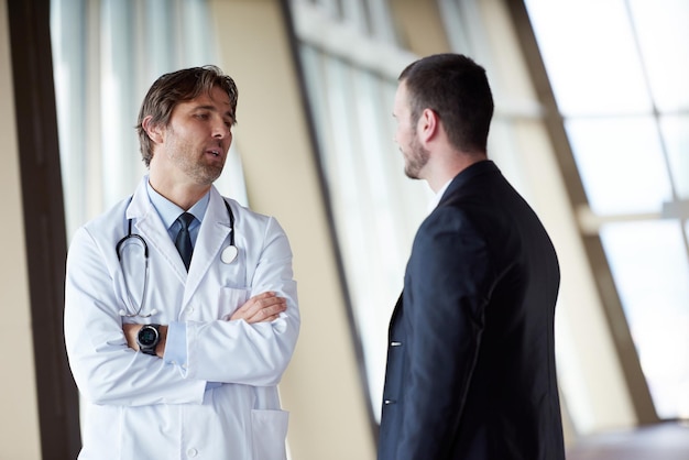 doctor handshake with a patient at doctors bright modern office in hospital