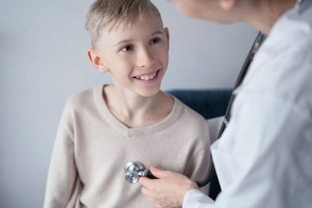 가정 의료 검사에서 의사와 행복한 웃는 어린 소년 환자. 의학, 의료 개념