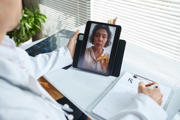 Foto dottore in videoconferenza con un paziente malato