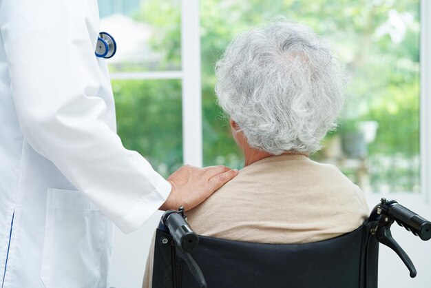 Doctor help Asian elderly woman disability patient in nursing hospital medical concept