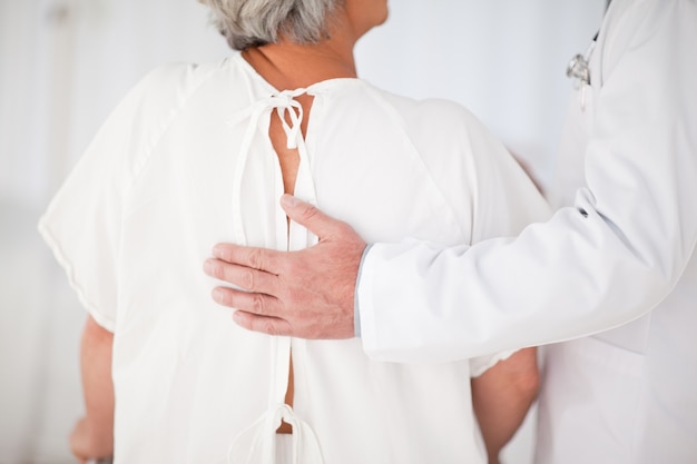 Doctor helping his patient to walk