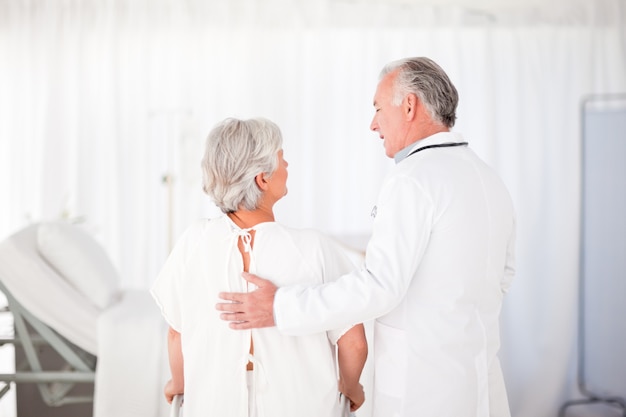 Doctor helping his patient to walk