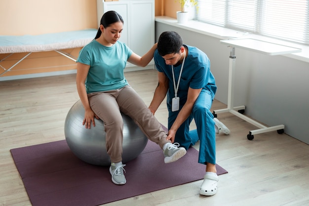 Doctor helping patient during rehabilitation