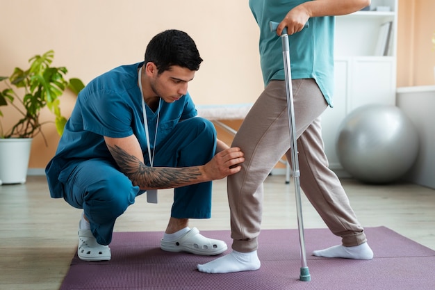 Doctor helping patient during rehabilitation