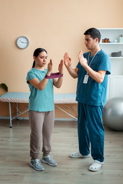 Doctor helping patient during rehabilitation