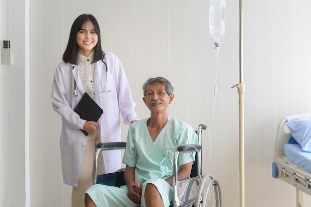 Doctor helping senior patient man moving to wheelchairs at hospital