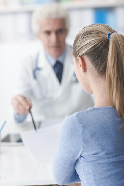 Doctor in his office showing medical records to the patient