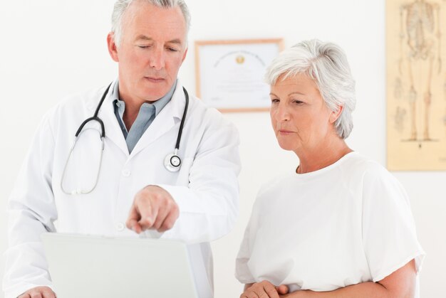 Photo doctor and his patient looking at the laptop