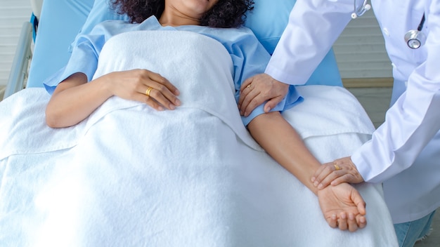 Doctor hold hand of patient on bed in hospital and checkup nervous system for cure and treatment. Concept of Guillain barre syndrome and numb hands disease or vaccine side effect.