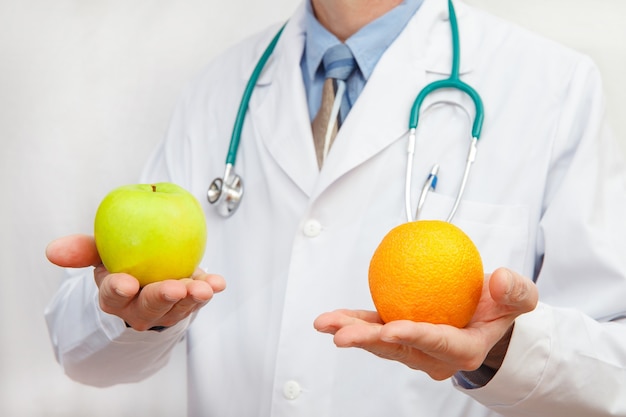 Doctor holding an apple and an orange