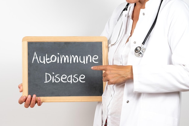 Doctor holding a blackboard with the Autoimmune Disease text