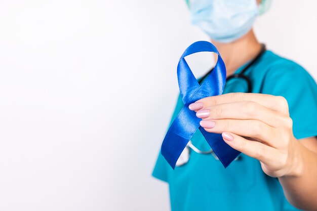 Doctor holding blue awareness ribbon