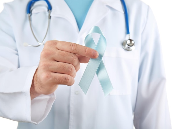 doctor holding blue ribbon on white background cancer awareness concept