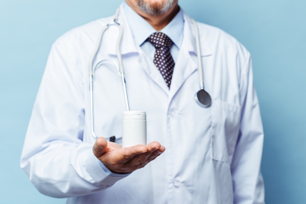 Doctor holding bottle of pills on white background. The concept of medicine, pharmacology, healthcare