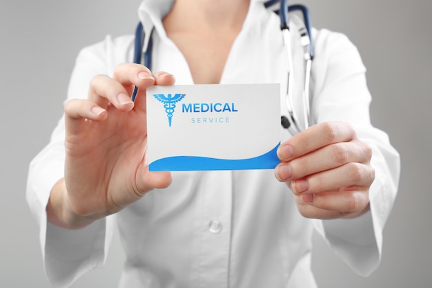 Photo doctor holding business card closeup