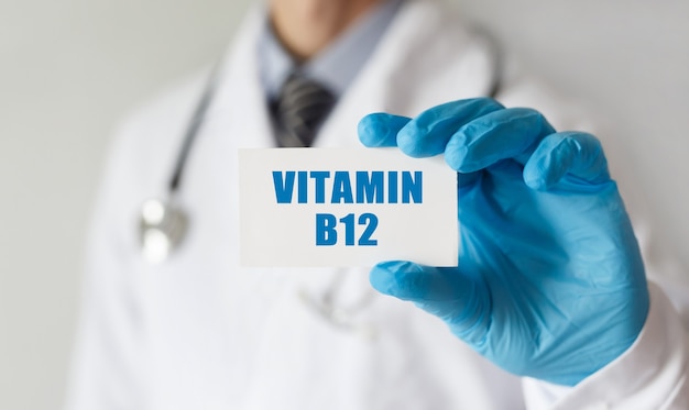 Medico in possesso di una scheda con testo vitamina b12, concetto medico