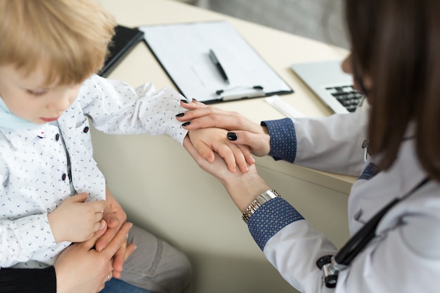 Medico che tiene la mano del bambino