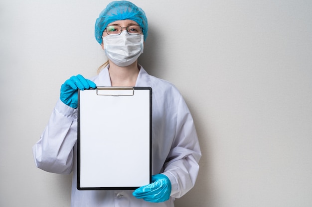 Doctor holding clipboard on light background