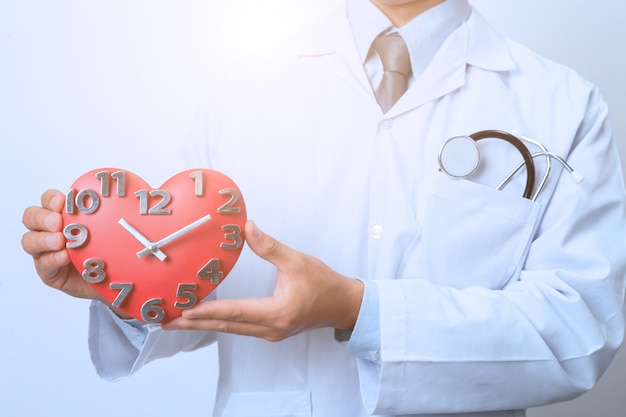 Photo doctor holding a clock,  concept for timing, medical and healthcare