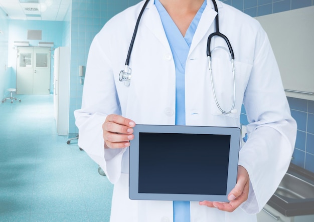 Doctor holding a digital tablet in corridor at hospital