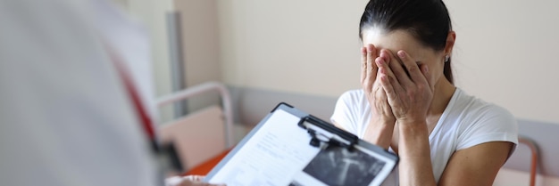 Doctor holding documents in front of crying patient in clinic psychological support for people