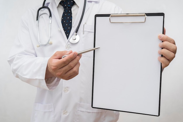 Doctor holding an empty clipboard with a pen pointing at the\
clipboard can insert text images