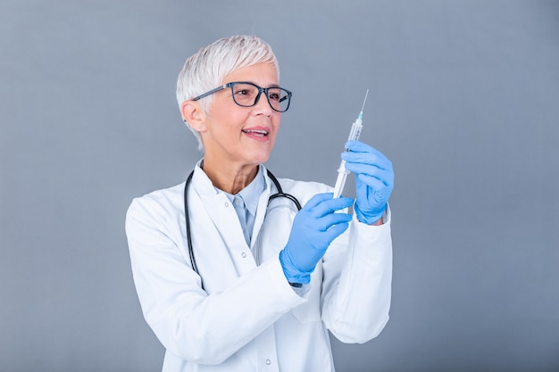 Doctor holding flu vaccine and syringe with needle