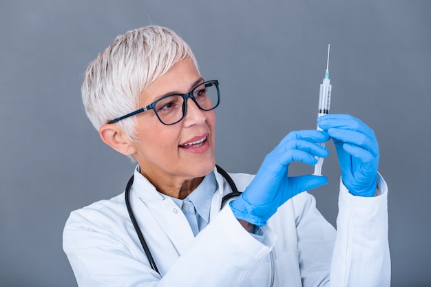 Doctor holding flu vaccine and syringe with needle