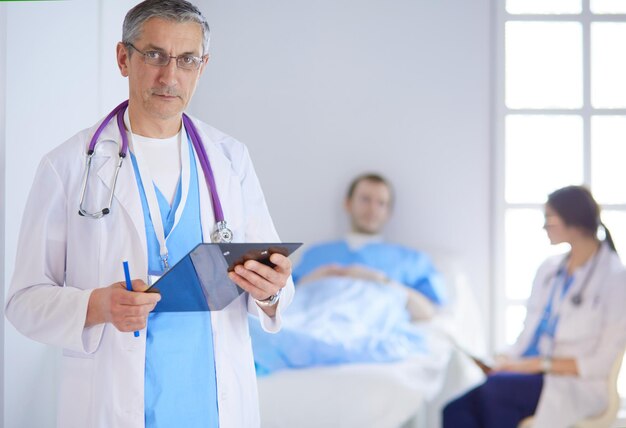 Doctor holding folder in front of a patient and a doctor