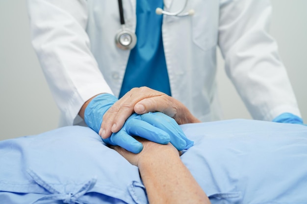 Doctor holding hands Asian elderly woman patient help and care in hospital