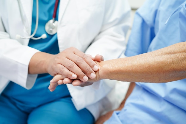 Doctor holding hands Asian elderly woman patient help and care in hospital