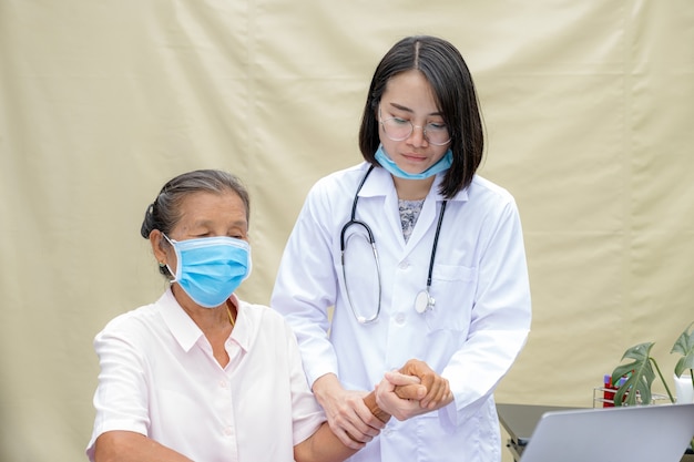 doctor holding hands to encouragement and explained health examination results to elderly patient